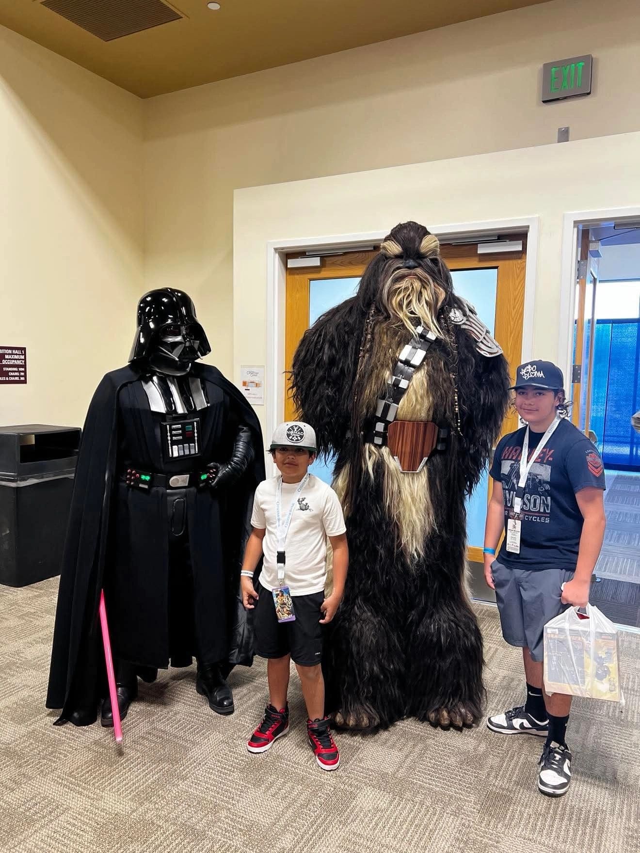 Children posing with Darth Vader and Chewbacca